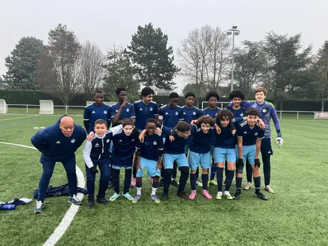 Groupe de jeunes joueurs du VFA et leur éducateur sur le terrain