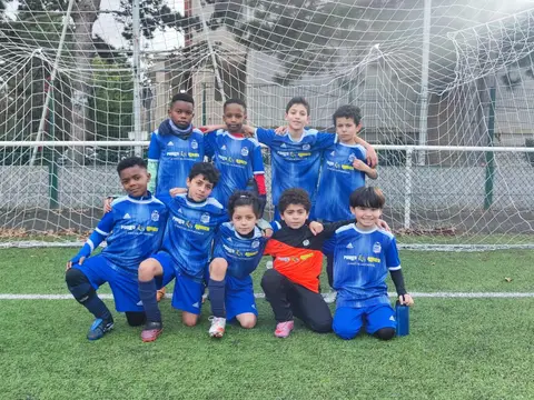 Jeunes joueurs du VFA en maillots bleus, accroupis devant le but